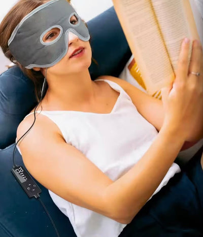 Woman reading on the sofa wearing the WarmVeil heated mask