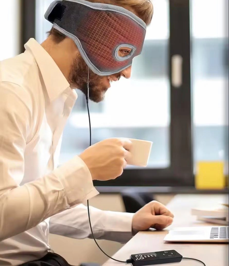 Man at his desk wearing the WarmVeil heated mask with a coffee